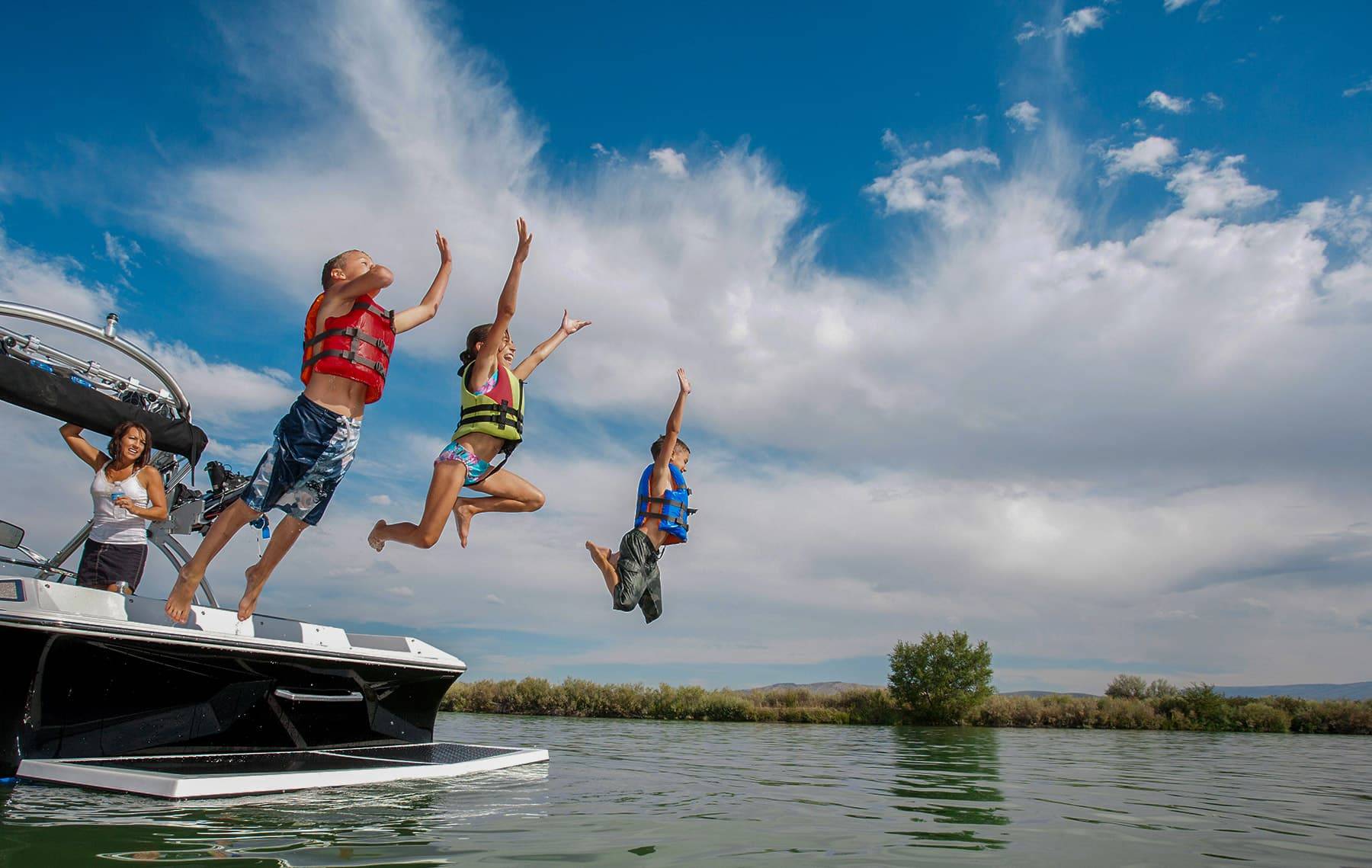 Home 1 Kids Jumping Into Lake From Boat